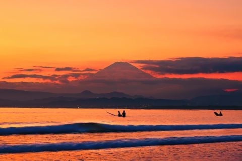 夕焼け空の富士とサーファー